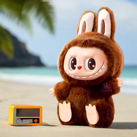 בובת פרווה חומה עם אוזני ארנב ליד רדיו צעצוע על חוף ים טרופי