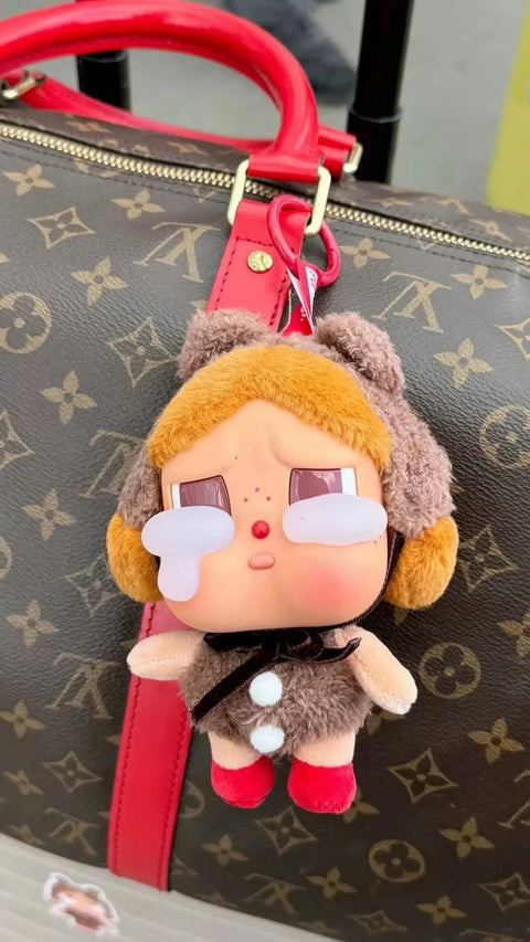 בובת פרווה בוכה מחוברת לתיק לואי ויטון חום עם ידית אדומה